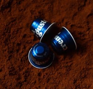 Tri plave crema e gusto classico aluminijske kapusle za kavu na mljevenoj kavi.