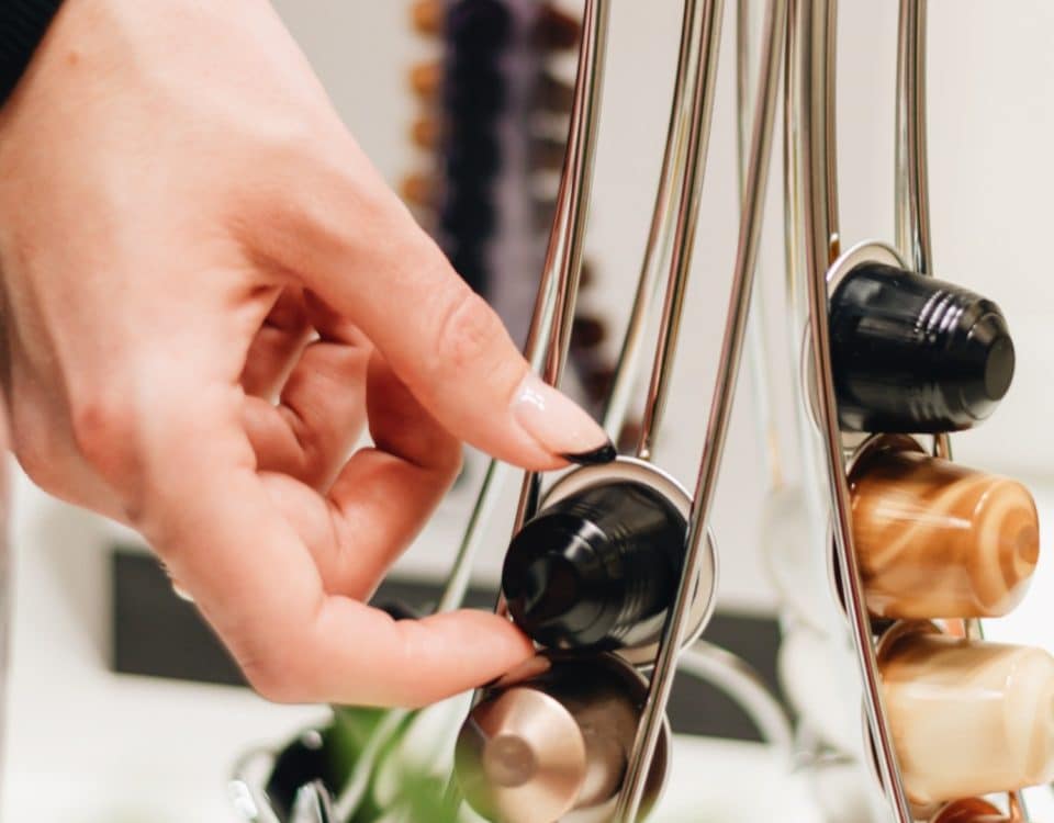 Slaganje kapsula za kavu različitih okusa na stalak za kapsule.